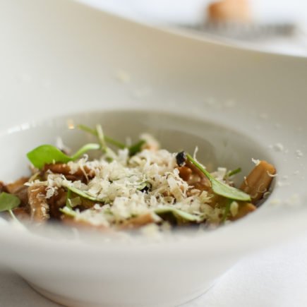 Open ravioli van varkenswang en bospaddenstoelen