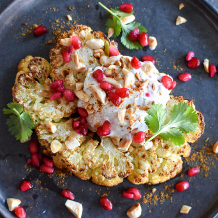 Bloemkoolsteak met yoghurt, ras el hanout en granaatappel