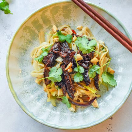 Wok met rijstnoedels, pulled duck en koriander