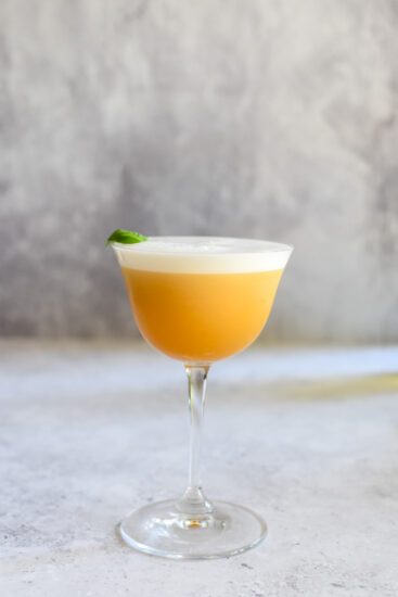 Sour cocktail met Elixir d’Anvers, sinaasappel, basilicum en rum