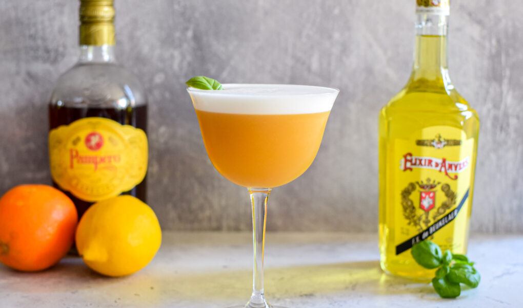 Sour cocktail met Elixir d’Anvers, sinaasappel, basilicum en rum
