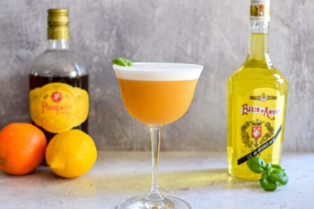 Sour cocktail met Elixir d’Anvers, sinaasappel, basilicum en rum