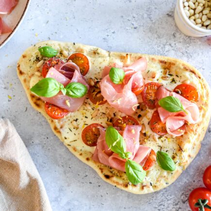 Makkelijke naanpizza uit de oven met tomaat en crème fraîche