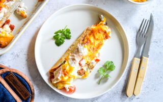 Merguez enchilada's met paprika, zure room en cheddar